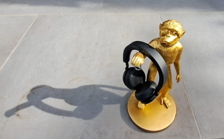 goldene Statue eines Affen, der schwarze Kopfhörer hält