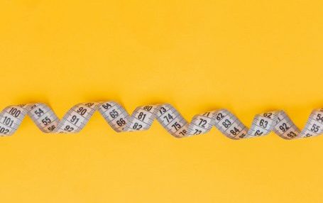 Messband aus Papier auf leuchtend gelbem Hintergrund.